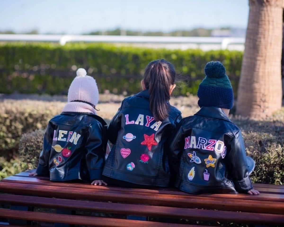 Three personalized denim shorts with tulle skirts hanging outdoors at a birthday party